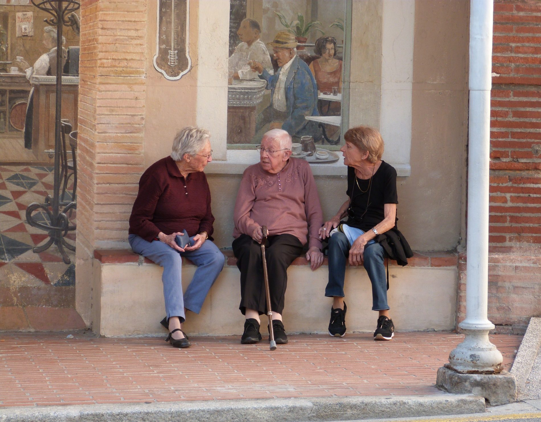 maury, trois dames discutent devant une fresque qui remémore le passé du village. Parc naturel régional Corbières-Fenouillèdes