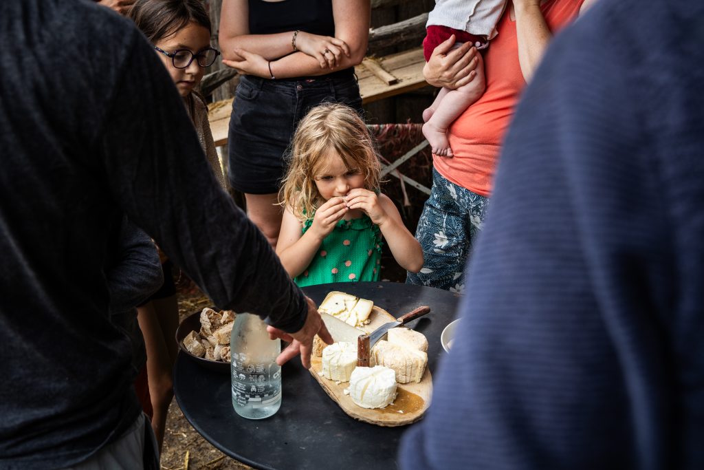 Jeune fille mangeant du fromage d'un éleveur à La Borde à Saint-Louis-et-Parahou