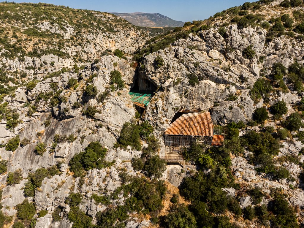 Vue aérienne sur le Caune de l'Arago et la grotte de l'homme de Tautavel protégé par une construction avec son toit en tuiles. Pyrénées-Orientales, Parc naturel régional Corbières-Fenouillèdes.