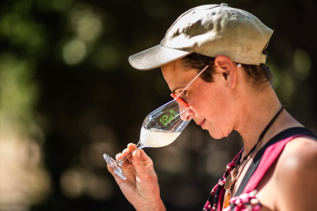Cliente d'un vigneron dégustant un verre de vin blanc pétillant. Petit marché à Latour de France.