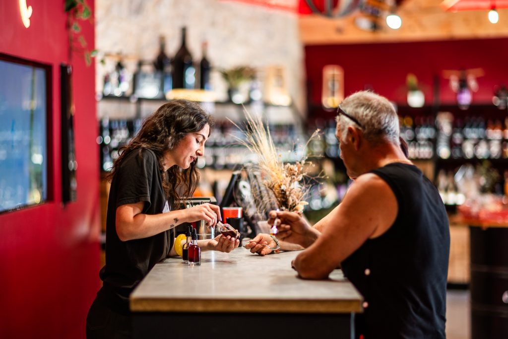 Couple de touristes se faisant présenter divers vinaigres et le goutant a la cuillère dans la boutique de la vinaigrerie de Cyril Codina à Lagrasse. Parc Naturel Régional Corbières-Fenouillèdes